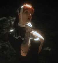 a woman in a black dress with tattoos