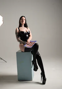 a woman in latex stockings sitting on a box