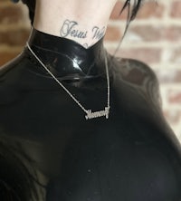 a mannequin with a tattoo on her neck and a necklace